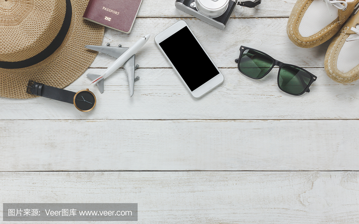 Top view女性配件旅行的概念。白色手机,飞机,帽子,护照,手表,太阳镜放在木桌上。